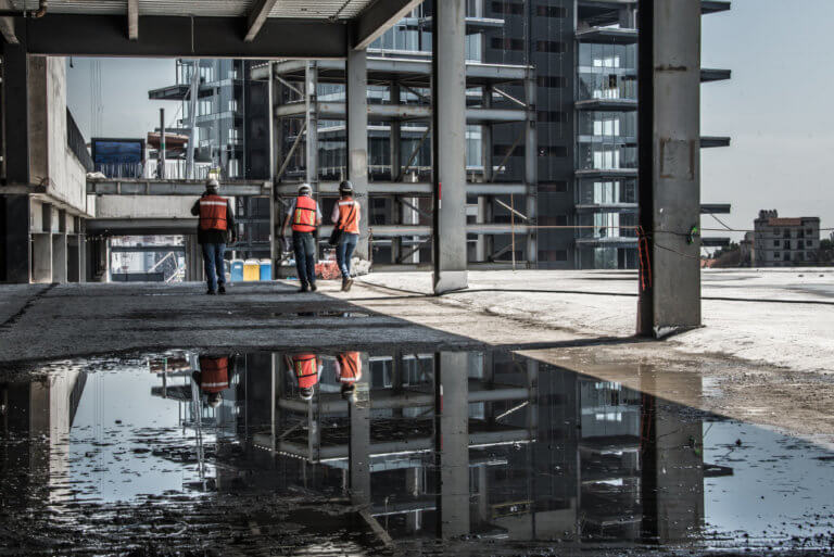 Demolição e embargo de obras - três trabalhadores em um prédio e construção