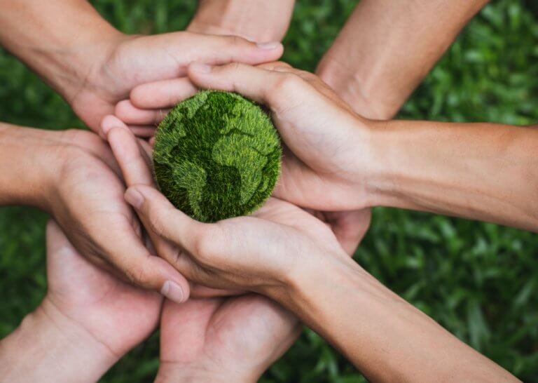 Responsabilidade social empresarial - mãos seguram um globo terrestre verde